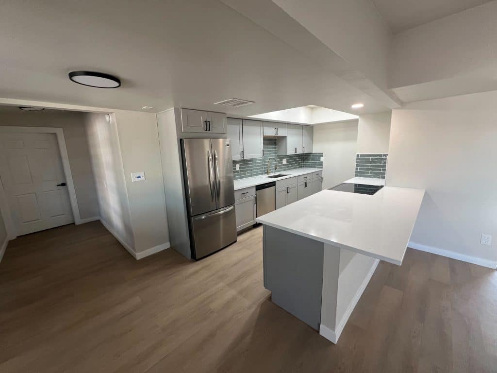 Open concept Tucson kitchen remodel with peninsula island and updated lighting by Kat Remodeling
