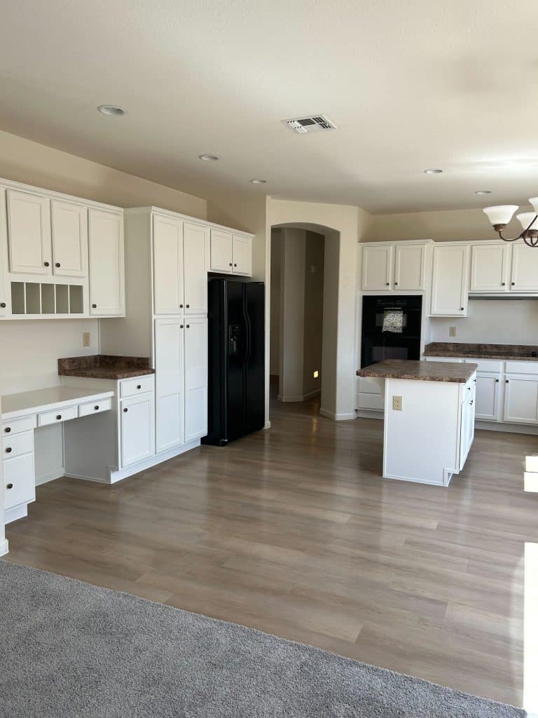 Open kitchen design with workspace nook and cohesive flooring transition – completed by Kat Remodeling, Tucson