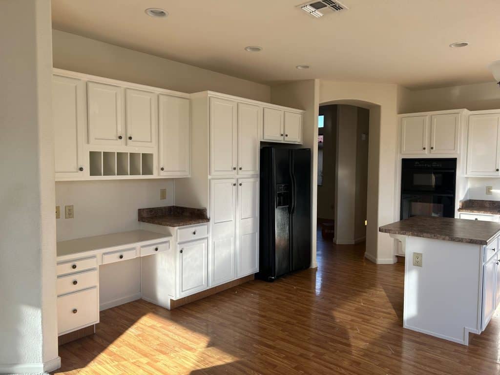 Remodeled kitchen with integrated desk area and laminate wood flooring – completed by Kat Remodeling, Tucson AZ