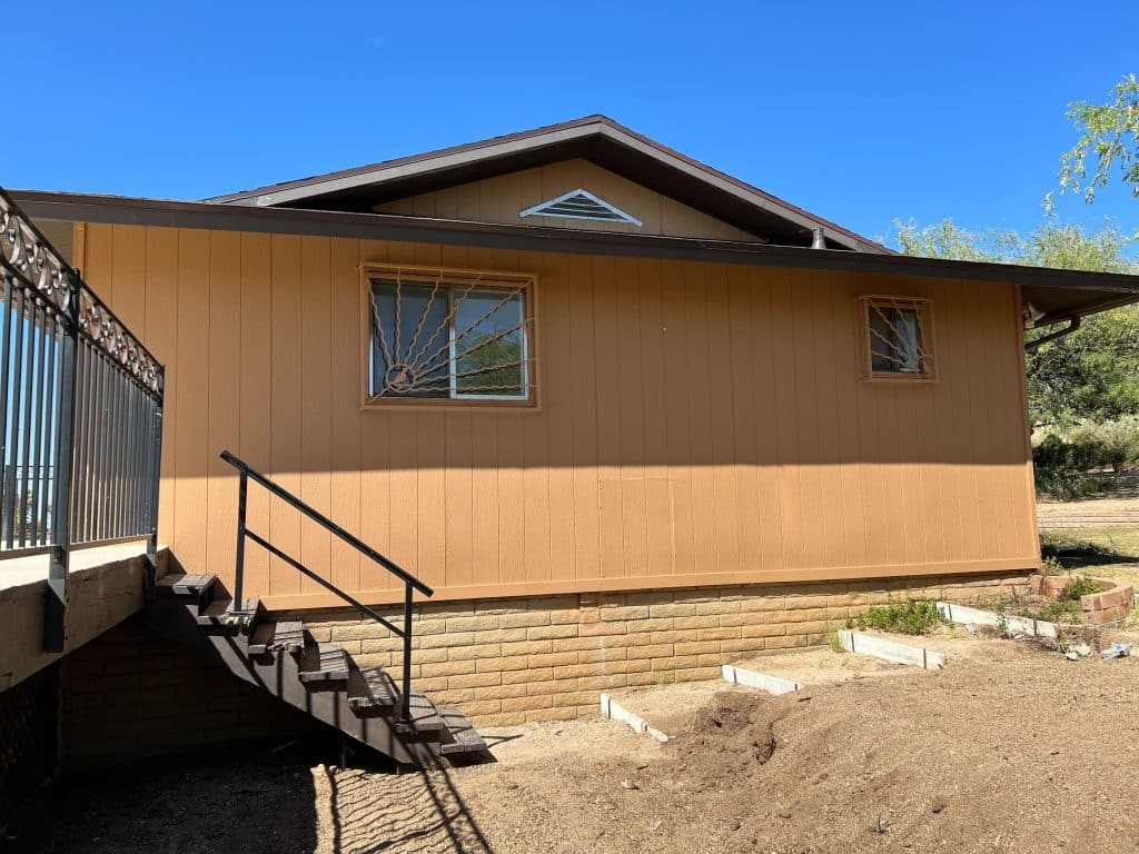 Side view of home with vertical panel siding and steel staircase by Kat Remodeling in Tucson, Arizona